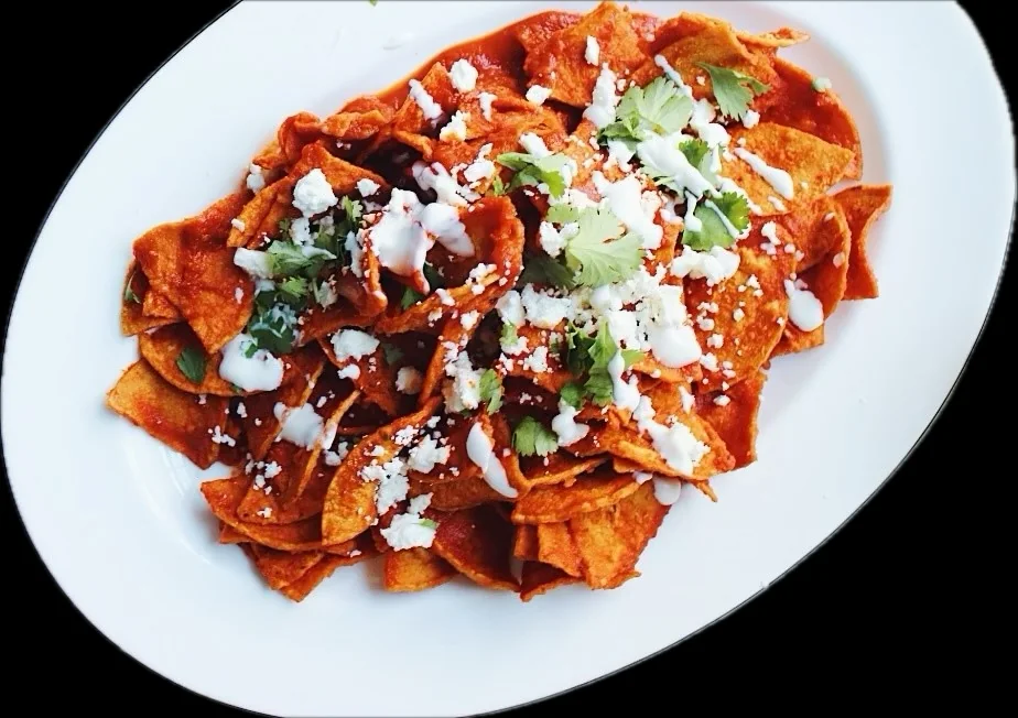 Red chilaquiles with crema, cheese, and cilantro