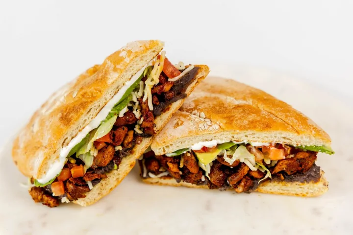 A toasted torta cut in half with meat and vegetables
